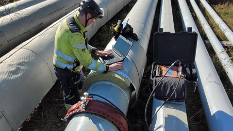 En man använder Long Range Screening, även känt som LRUT, för upphöjda och synliga rör. Provningen är en icke-förstörande metod för att snabbt hitta korrosionsskador i olika slags rörledningar utan att ta rören ur drift..