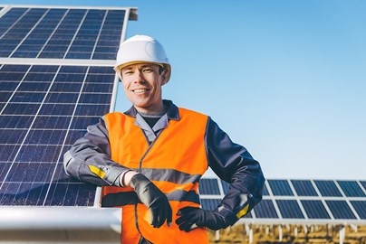 Werknemer leunend op zonnepanelen