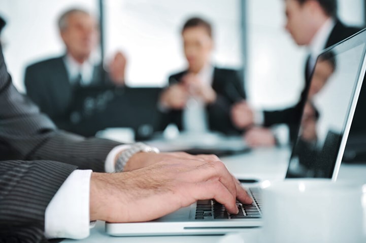 Man aan het werk op laptop tijdens een meeting