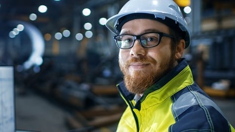 Medewerker met helm die vriendelijke de camera in kijkt