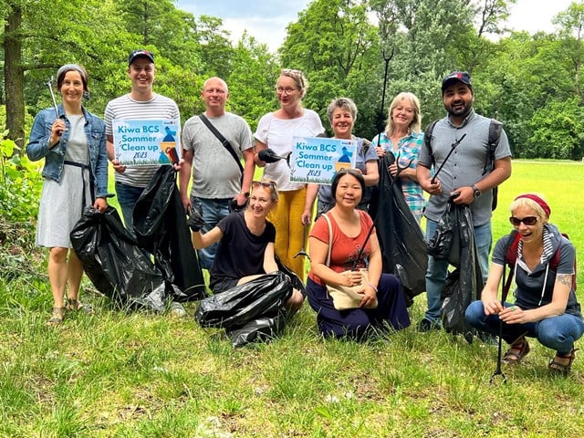 Group of people posing in nature with trash bags