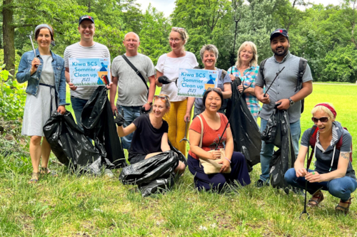 Group of people posing in nature with trash bags
