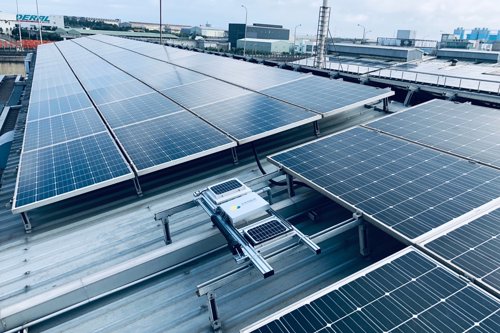 solar panels with dust analysis systems on the rooftop of a building in an industrial facility