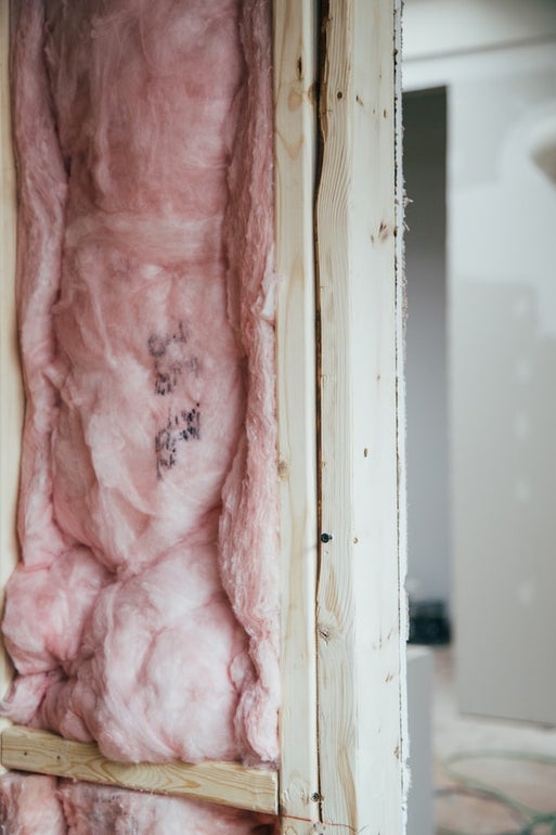 Pink thermal isolation material filling up the middle of a wodden column 