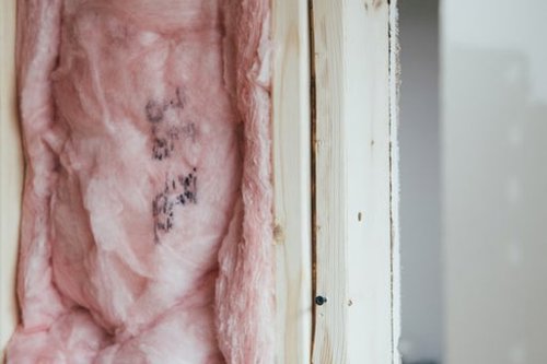 Pink thermal isolation material filling up the middle of a wodden column