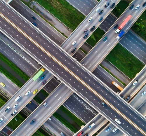 Aerial view of intersecting highways with moving vehicles.