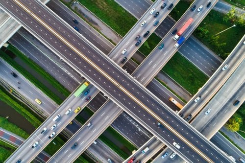 Aerial view of intersecting highways with moving vehicles.