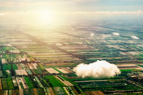 Cloud in front of green landscape