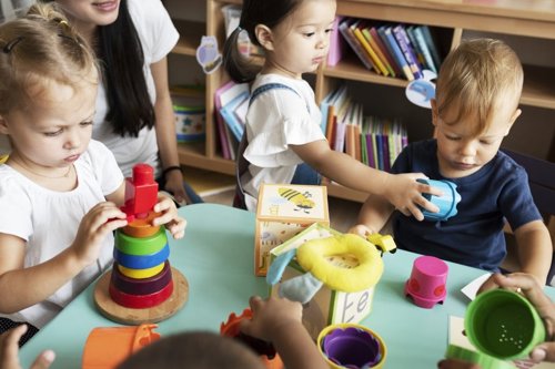 Kinderen spelen met educatief speelgoed aan een tafel in een klaslokaal