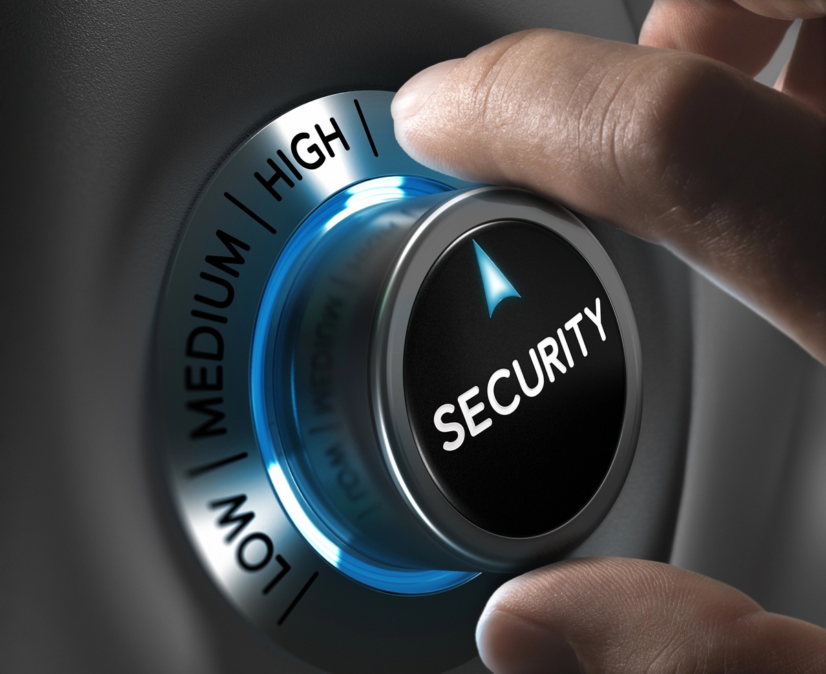 Hand draait aan een knop met opties "Low", "Medium" en "High", waarop "Security" staat aangegeven met een blauwe verlichting.