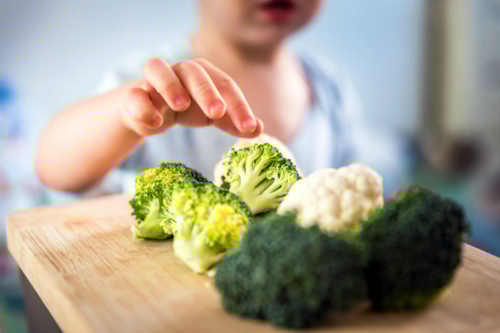 Child takes broccoli florets