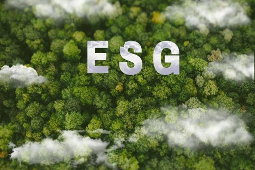 ESG letters over a lush green forest with clouds