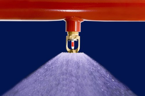Närbild på en sprinkler som sprutar vatten.