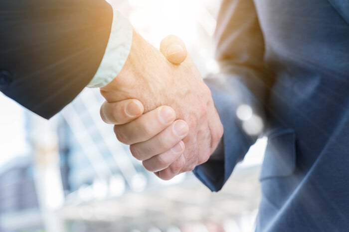 Business handshake between two men in suits, symbolizing partnership and agreement