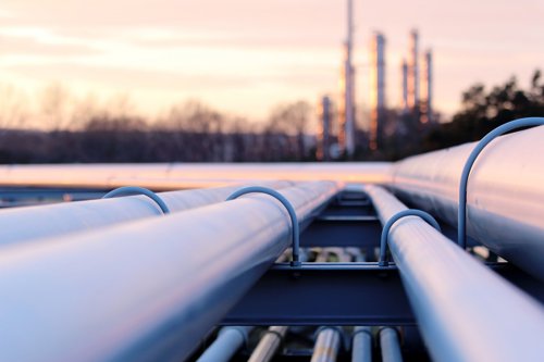 Industrial pipeline network and smokestacks in the background
