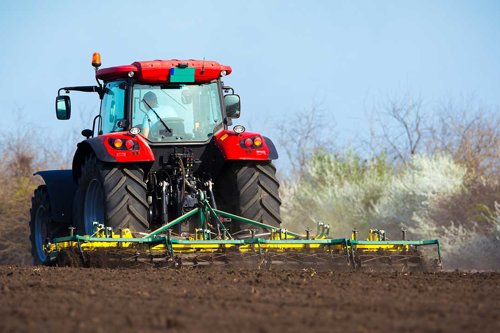 Traktor kör på åker