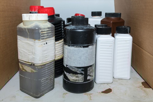 Felaktigt förvarade brandfarliga kemikalier i omärkta plastflaskor.