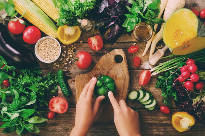 Top down view of two hands chopping up Kiwa certified vegetables