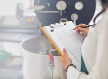 Technician working on a report in a food lab as a part of Kiwa consulting